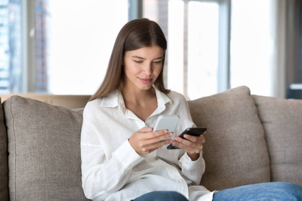 istock Engaged digital addict girl using two smartphones for data 1463545884