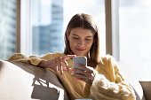 Happy peaceful smartphone user girl chatting online