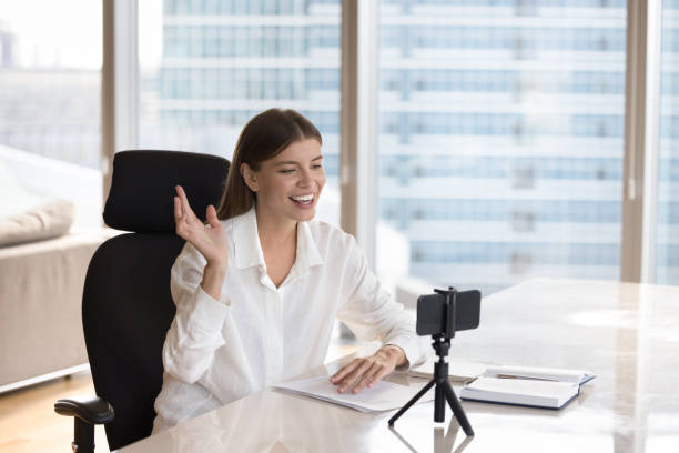 Happy cheerful blogger, vlogger girl speaking smartphone webcam