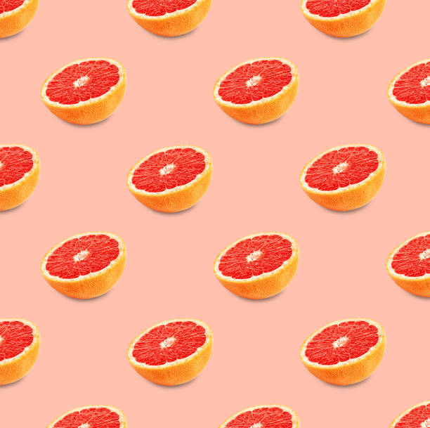 istock Many fresh ripe grapefruits on pink background. Seamless pattern design 1463546032