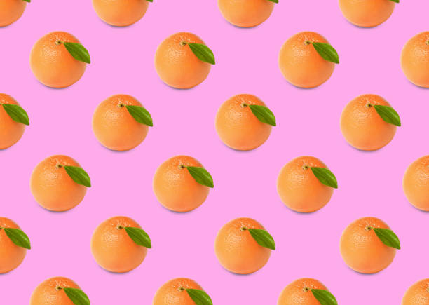 istock Many fresh ripe grapefruits on pink background. Seamless pattern design 1463546037