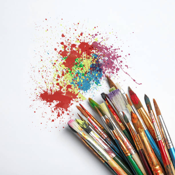 istock Different brushes and paint splatters on white background, top view 1463546545