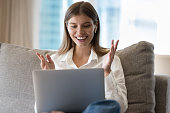 Excited cheerful pretty 30s laptop user woman staring at display