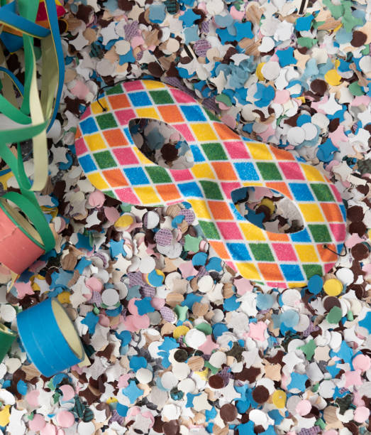 istock Carnival themed background with Harlequin mask over confetti, buglers and streamers 1463547932