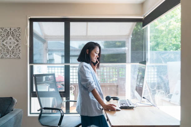 istock Young woman having a call on phone while working from home. 1463552811