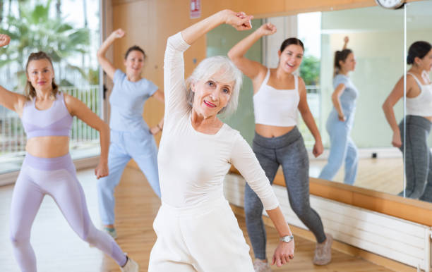 istock Cheerful senior female choreographer showing new dancing dynamic movements during training together with women in studio 1463553510