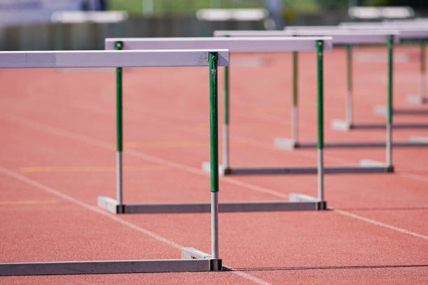 hurdles on a athletics track - hurdling imagens e fotografias de stock