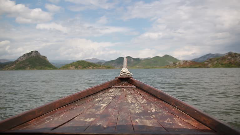 View on a wooden tourist boat in the middle of Skadar Lake, Montenegro. Lake trip in mountains in National Park in summer.