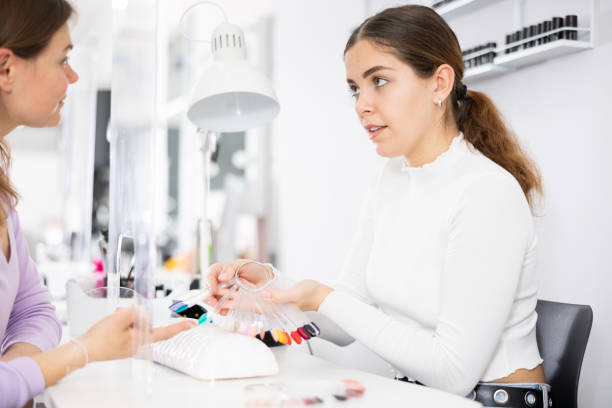 istock Manicurist demonstrating a palette with lacquer color schemes to a client 1463555217