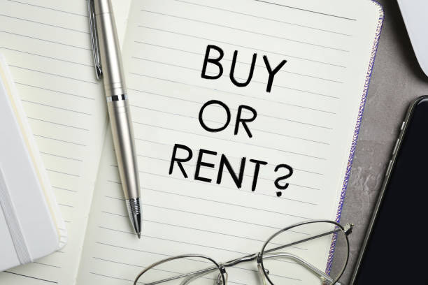 istock Buy or rent - choice concept. Notebook, pen, glasses and smartphone on grey table, flat lay 1463555323