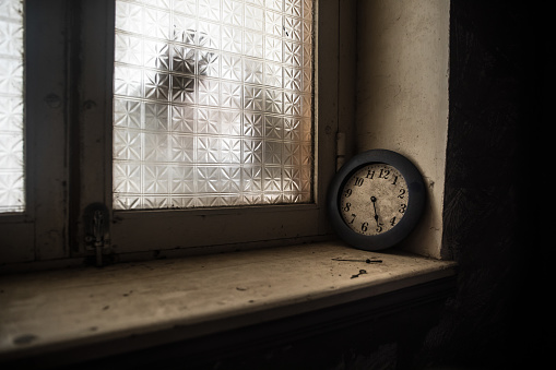 Old and vintage blank clock dial without hand on old wooden windowsill. Studio shot