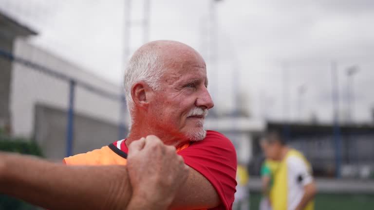 Portrait of a senior man stretching before a match on the soccer field