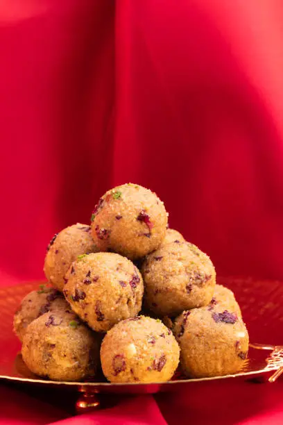 Photo of Indian Mithai Gulab Churma Ke Laddu Or Choorma Ke Ladoo Is Made Of Whole Wheat Jada Gehun Ka Atta, Khus Khus, Gur, Jaggery, Kaju, Badam, Edible Rose Petals, Dry Fruits In Desi Ghee Or Clarified Butter