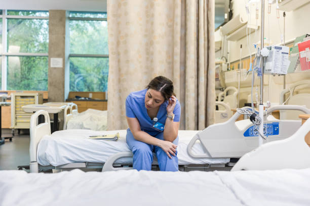 istock Exhausted female nursing student sits on hospital bed 1463564260
