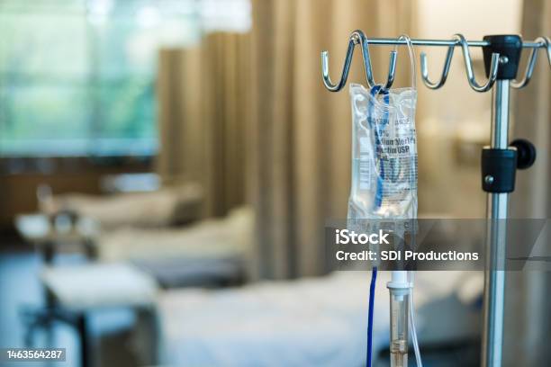 Focus On Iv Bag And Stand In Empty Hospital Ward Stock Photo - Download Image Now - IV Drip, Liquid, Drinking