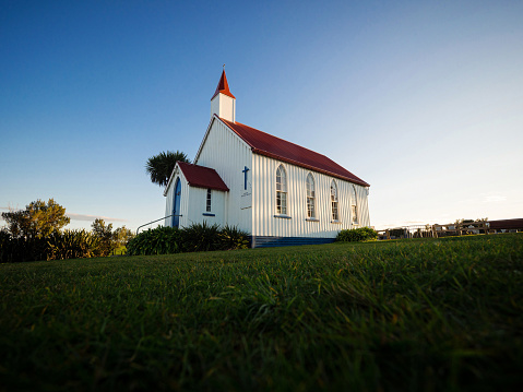 Old historic 19th century white presbyterian Awhitu Central Church with green grass during sunset on Manukau Heads Peninsula Auckland North Island New Zealand