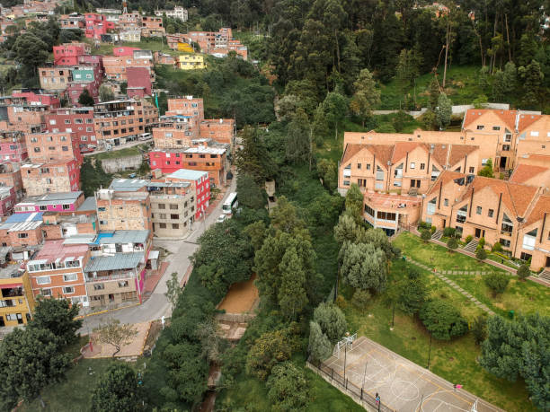 Urban Inequality in Bogotá, Colombia A wealthy gated community bordering a slum in Bogotá, the capital city of Colombia marxism stock pictures, royalty-free photos & images