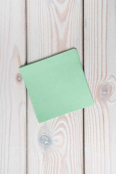 istock Flat lay of empty blank green sticker sticky note on grey wooden table. Note, paper, reminder, information, memory. 1463575244