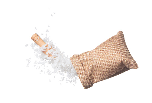 Salt flying in sack bag, crystal white grain salts explode abstract cloud fly. Beautiful complete salt sack bag splash in air, food object design. White background isolated high speed freeze motion