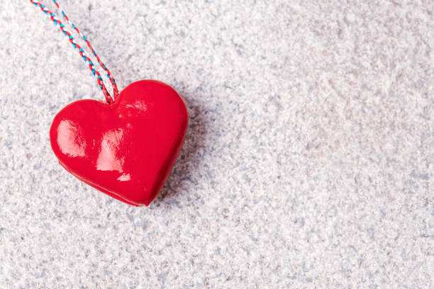 Red toy heart on granite stone textured background. Valentines day concept. Top view, flat lay, copy space.