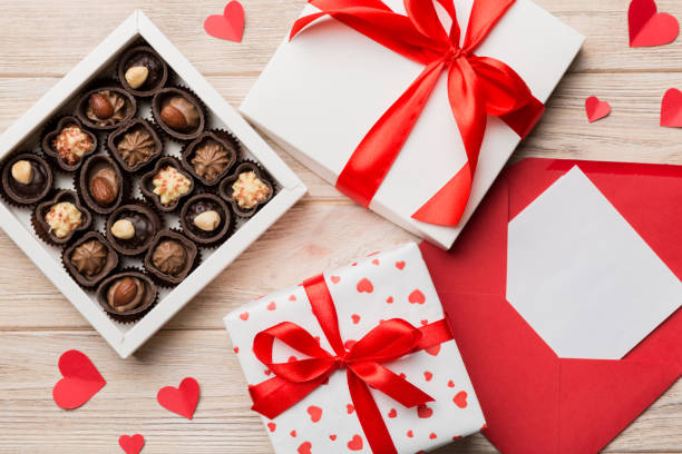 istock Envelope on colored background for Valentine Day with gift box and chocolate. Heart shaped with gift box of chocolates top view with copy space 1463587135