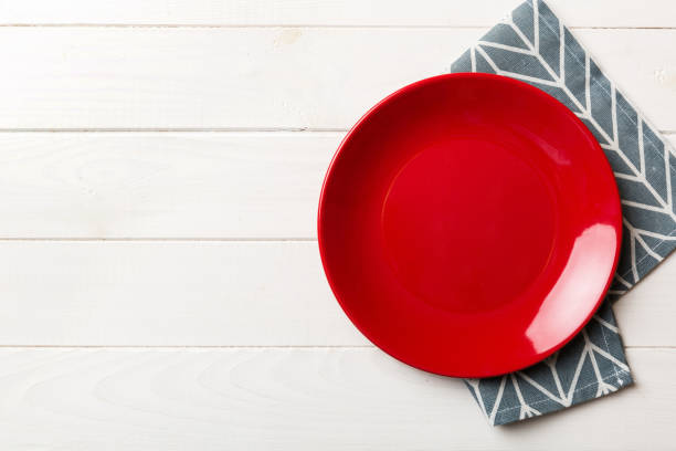 istock Top view on colored background empty round red plate on tablecloth for food. Empty dish on napkin with space for your design 1463587154