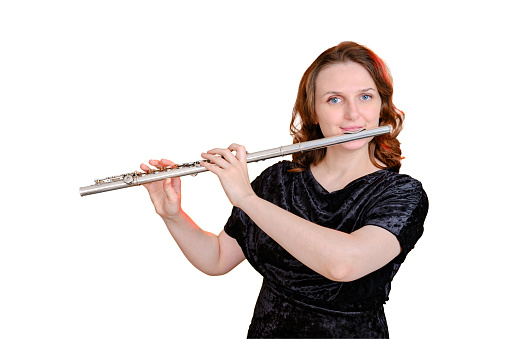 Portrait of a woman musician with a flute on a studio isolated white background. Flutist with a large concert transverse flute in her hands