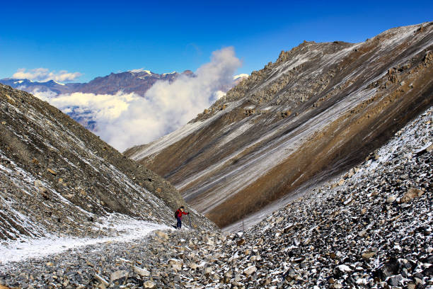 A trekker begins the descent from Thorung La pass into the Kali Gandak Valley towards Muktinath, Mustang on the Annapurna Circuit trek