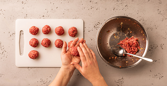 Cooking - chef making a minced meatballs. Preparing dinner - worktop captured from above (top view, flat lay).