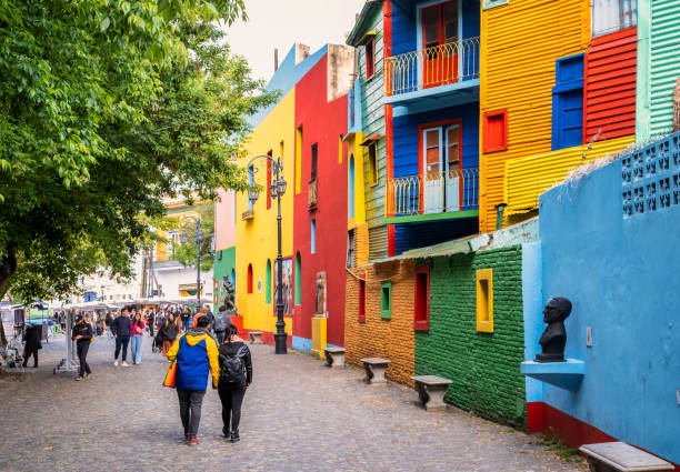 Tourists walk in Caminito, in La Boca district - Buenos Aires, Argentina La Boca, Buenos Aires, Argentina - October 29, 2022 - Tourists walk in Caminito, a typical street with colorful houses in La Boca district with colorful buildings - Buenos Aires, Argentina la boca buenos aires stock pictures, royalty-free photos & images