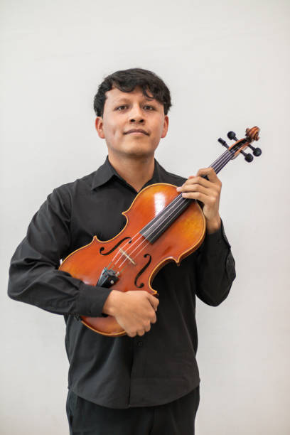 istock young viola player, hispanic violist standing smiling against a white wall background 1463607311