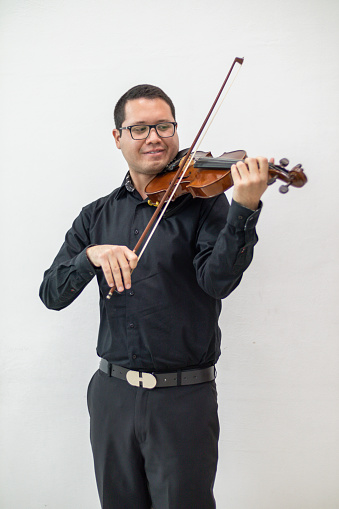 hispanic violin player dressed in black  playing violin