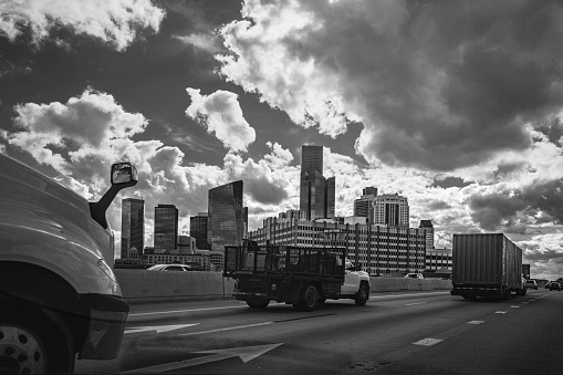 Retro-style black and white Houston Texas downtown buildings and city skyline with dramatic clouds over the metropolitan highway