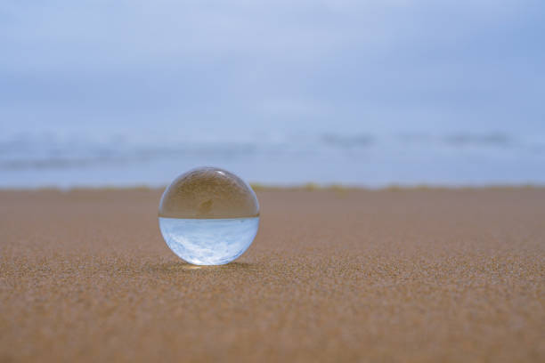 istock Abstract seascape, glass ball o sand beach at sunset, copy space for text. Relaxation, vacation concept 1463611547