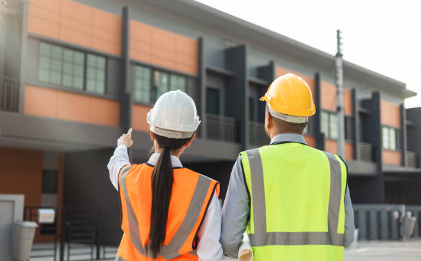 istock Two Asian worker engineer architect man and woman architect looking construction with white safety helmet in modern home building construction. Work planning with blueprint and tablet. 1463615664