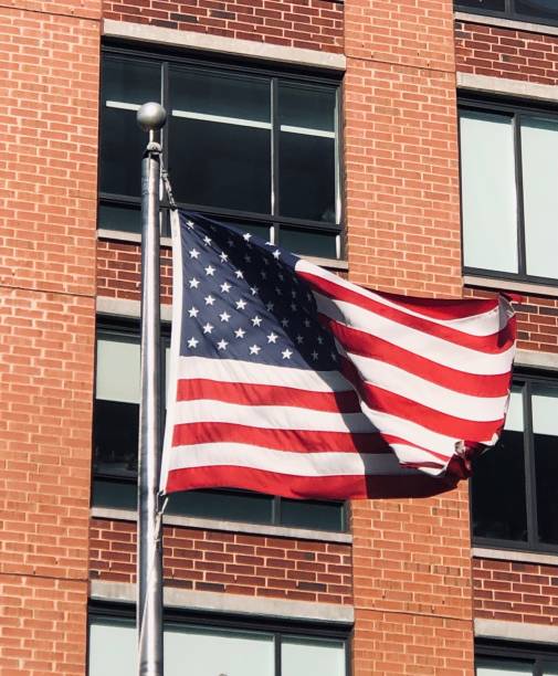 istock American Flag In Front of Brick Building 1463615713