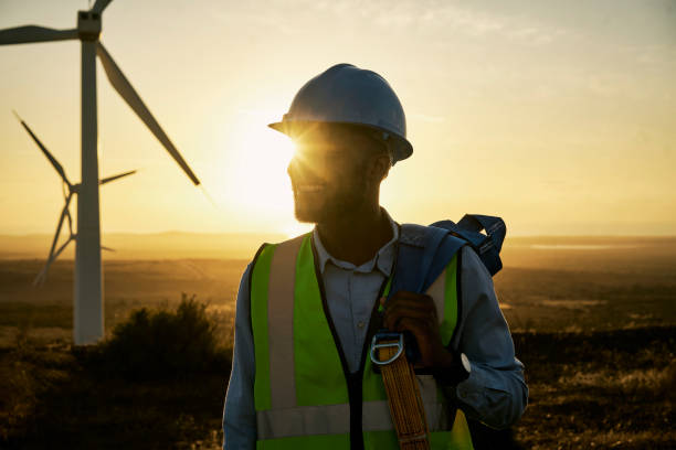 istock Windmill ,renewable energy and engineer man in the countryside for industrial, development and innovation. Engineering, wind and turbine by black guy with vision for future, sustainability and power 1463616236