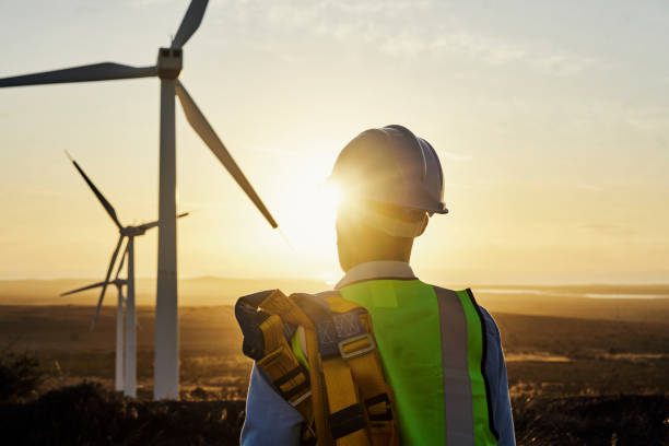 istock Renewable energy, windmill and back of engineer man in countryside for industrial, development and innovation. Engineering, wind and turbine with guy with vision for future, sustainability and power 1463616241