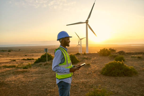 istock Engineer man, tablet and windmill on farm for renewable energy, power and electricity. Electrician or technician person in nature for wind turbine, eco and green environment innovation maintenance 1463616272