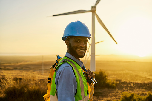Wind turbine, clean energy and black man engineer smile in portrait, electricity and environment with sustainability. Renewable, engineering with agriculture, nature and windmill inspection mockup