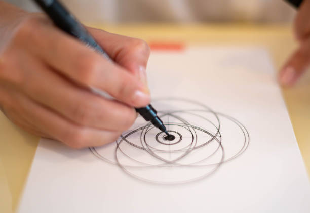 istock A female hand using a black magic pen preparing to draw and sketch the mandala concept on the empty white paper. 1463621811