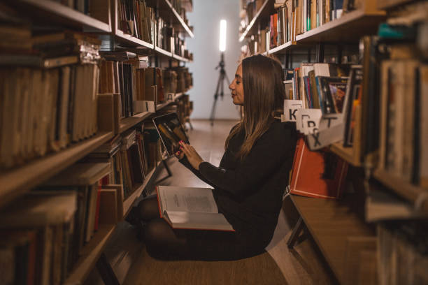 istock The librarian is reading a book and using a digital tablet in the library 1463626151