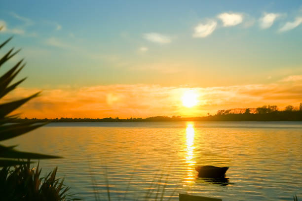 istock Small dinghy at anchor in silhouette back-lit by intense sunrise 1463628186