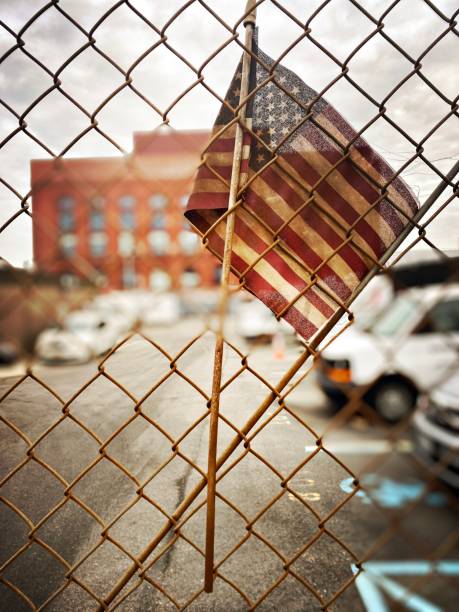 istock American Flag Intertwined in a Chained Link Fence 1463633716