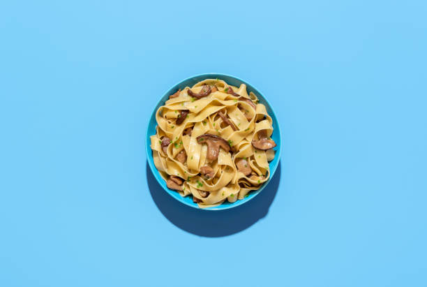 Mushroom pasta dish, above view on a blue background stock photo