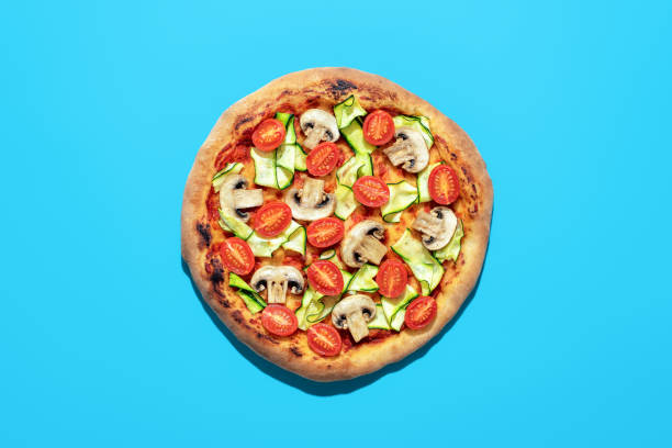 istock Vegan pizza above view, isolated on a blue background 1463637506