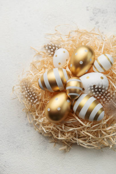 istock Easter eggs painted with gold paint on a straw background 1463638765