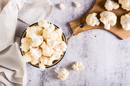 A bowl of raw cauliflower is on the table. Vitamin and vegetarian food. Top view