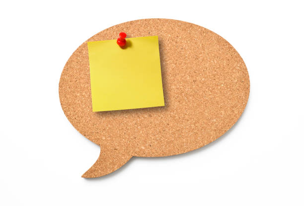nota adesiva gialla fissata con puntina da disegno rossa su un fumetto in sughero - bulletin board speech bubble paper thumbtack foto e immagini stock