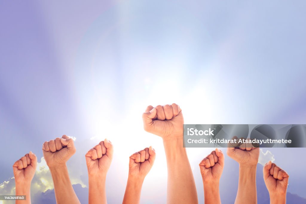 Peoples raised fist air fighting and sunlight effect, Competition, teamwork concept, background space for text. Adult Stock Photo